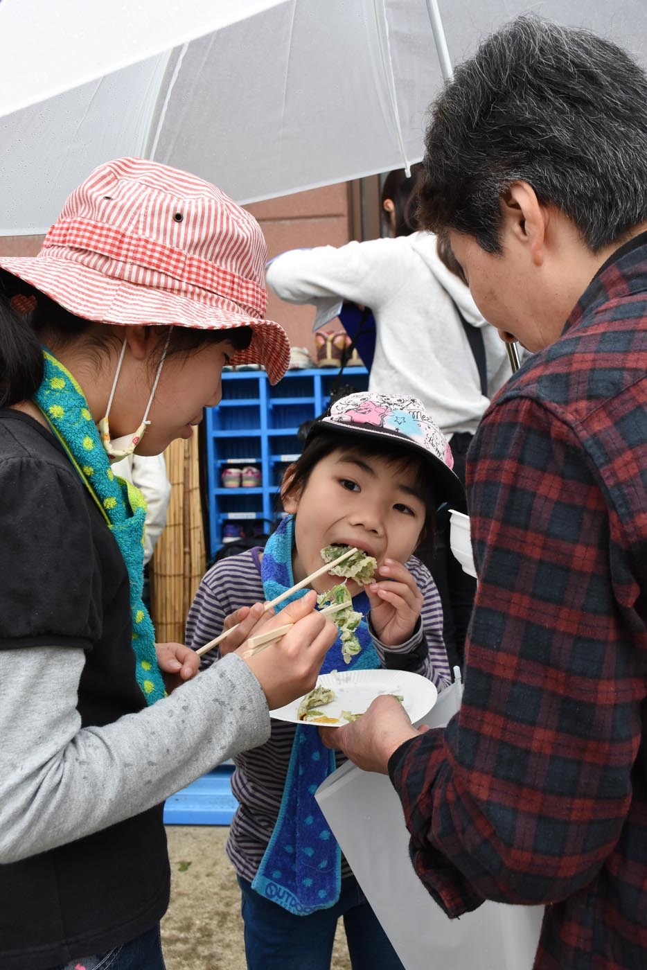 大きな口で野草の天ぷらを食べる子ども