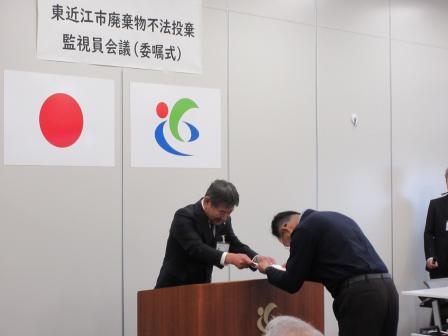 写真：市廃棄物不法投棄監視員委嘱式で委嘱状を渡す市長