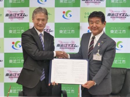 写真：調印を結んで握手する旭化成住工株式会社の方と市長
