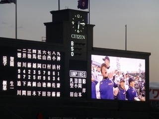 写真：甲子園球場の得点板と大型スクリーンに映る客席の高校生ら