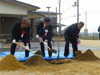 写真：竣工式で関係者らと植樹する市長