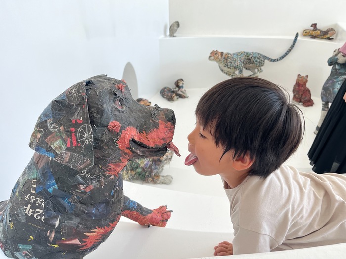 犬の作品とそれを見る男の子の写真
