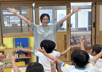 写真：子どもたちに囲まれる保育教諭