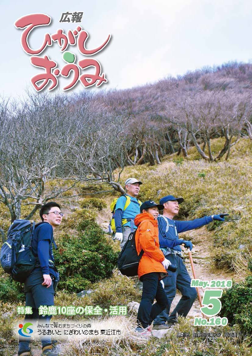 山道で立ち止まり遠くを指さす登山者4人が写る表紙の写真