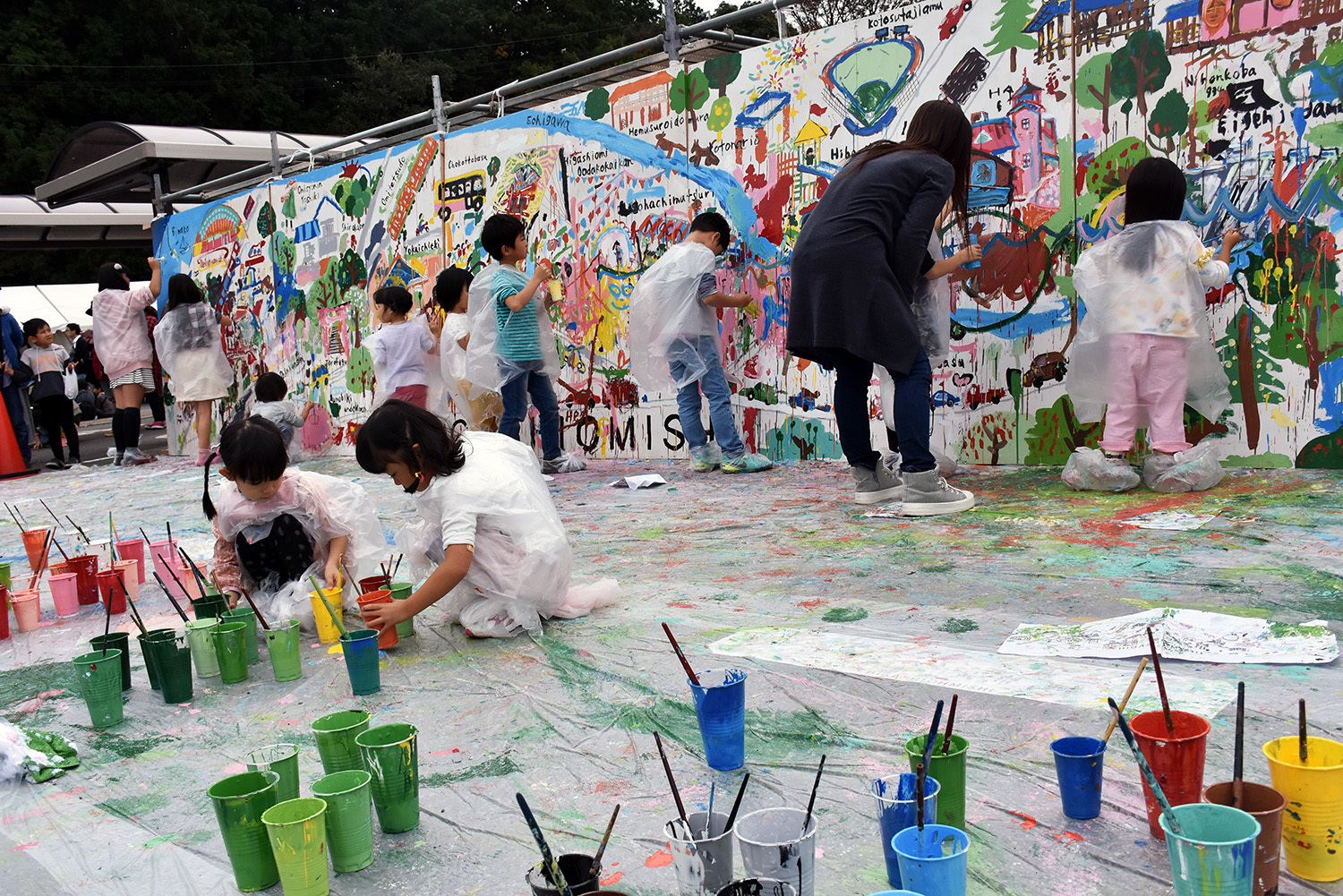 巨大なキャンバスに東近江市をイメージした絵を描く参加者